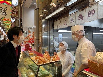 京都・錦市場にある三木鶏卵 本店の店頭で話をする様子
