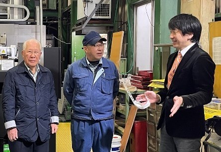 高橋精機の工場に並ぶ取締役会長・代表取締役社長とシェアビジョンの担当者
